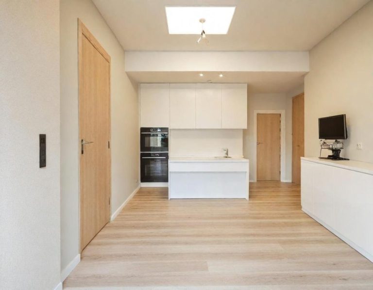 Helle, moderne Küche mit Holzfußboden, weißen Möbeln und großen Fensterflächen.